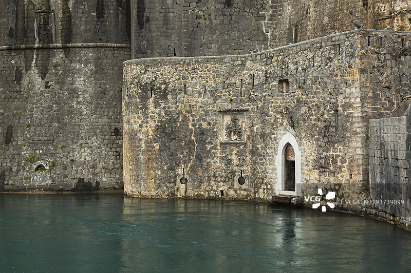 黑山科托尔老城的古老石头防御工事，南门和池塘，晚夏时节图片素材