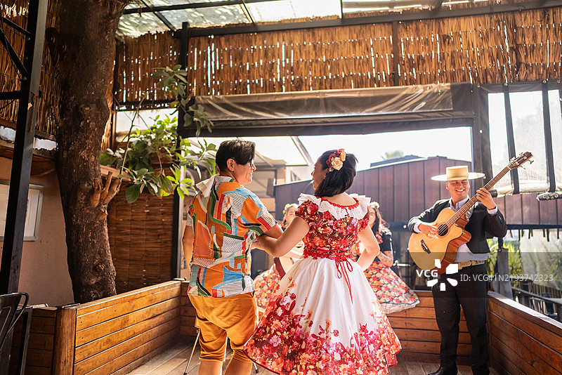 成熟的男性游客在智利的民俗cueca活动中与huasa共舞图片素材