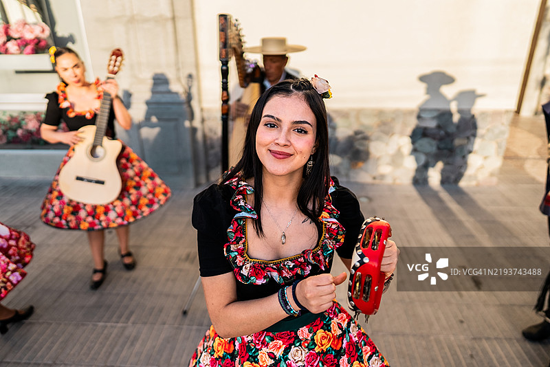 在智利圣地亚哥的民俗cueca活动中，一位胡阿萨人正在演奏铃鼓的肖像图片素材