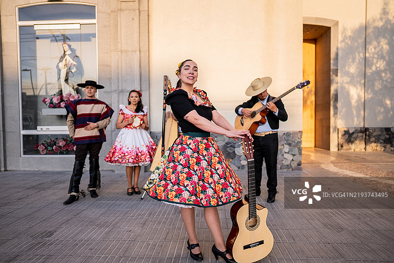 在智利圣地亚哥的民俗cueca活动中，一位华萨手持吉他的肖像图片素材