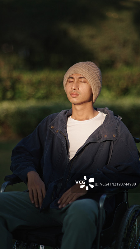 坐在轮椅上的男性病人放松身心。图片素材