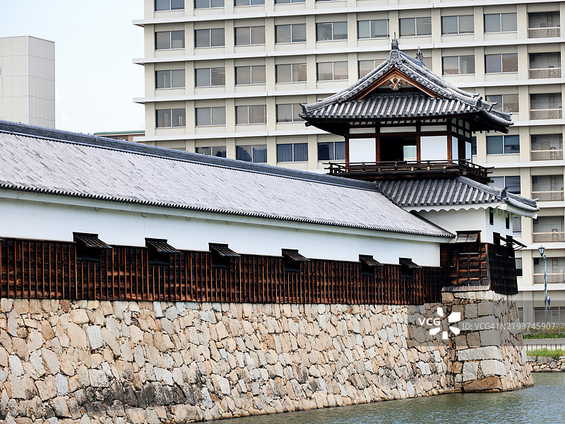 日本广岛的广岛城太鼓阁塔和护城河，背景是办公大楼图片素材
