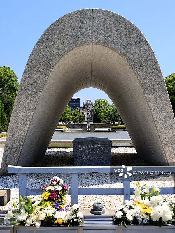 广岛和平纪念公园内的原子弹受害者纪念碑，背景是原子弹圆顶建筑图片素材
