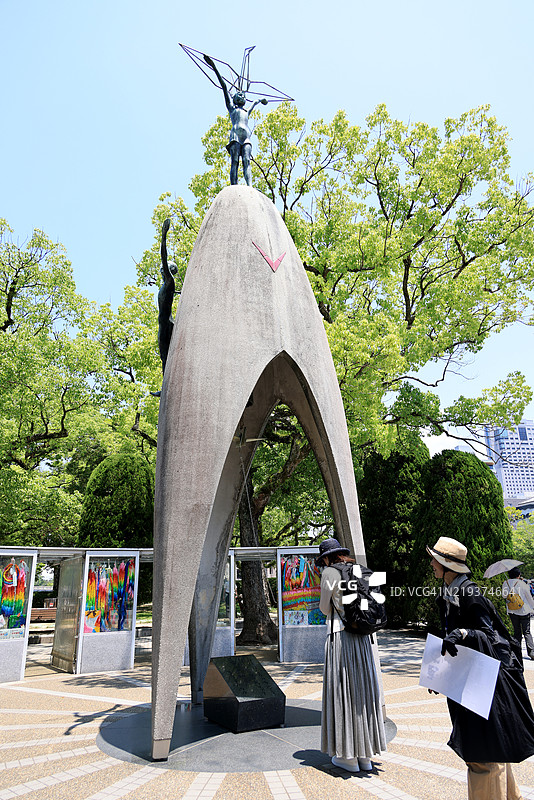在日本广岛和平纪念公园的儿童和平纪念碑前祈祷的女性图片素材