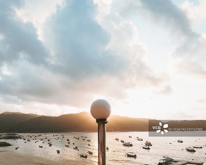 在马来西亚登嘉楼的佩亨提安岛，日出被路灯挡住。图片素材