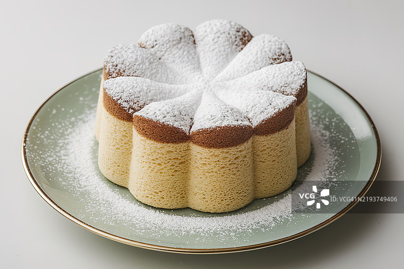 一块撒有糖粉的甜海绵蛋糕放在盘子上图片素材