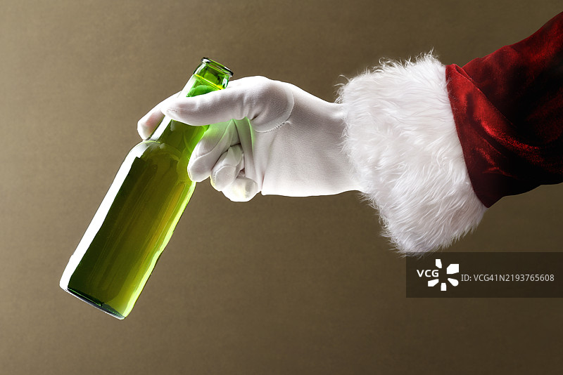 圣诞老人手中拿着一瓶打开的啤酒图片素材