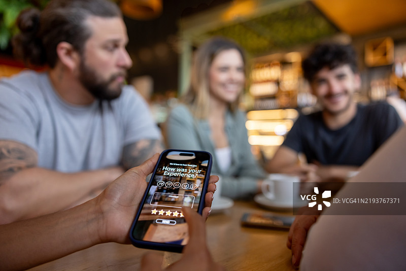 顾客用手机对餐厅的体验进行评分的特写镜头图片素材
