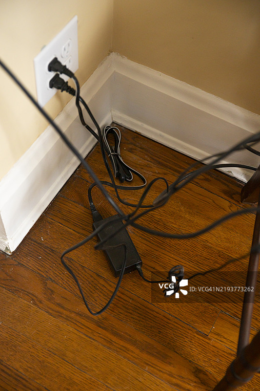 电源线，笔记本电脑充电器线，靠近电源插座的缠绕电缆图片素材