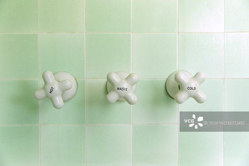 淋浴水龙头，冷热水概念，浴室瓷砖背景图片素材