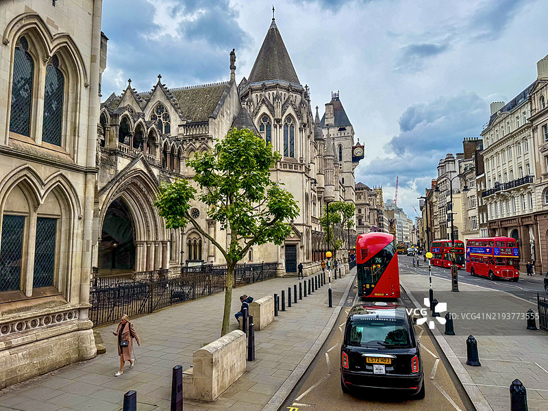 一位女性在皇家法庭外走路时看着手机图片素材