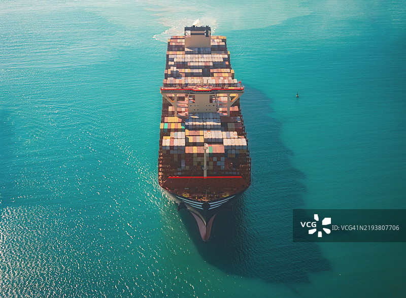 航拍前视图，集装箱货船满载集装箱，从商业港口的码头出发，适用于商业物流、进出口、航运或货物运输。图片素材