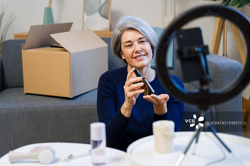 微笑的成熟的女性网红正在为她的粉丝录制美容教程图片素材