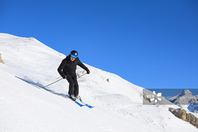 滑雪冬季运动。英俊的运动员在阳光明媚的滑雪胜地享受滑雪。欧洲阿尔卑斯山的雪山，滑雪区域瓦尔迪泽尔 - 蒂涅。图片素材