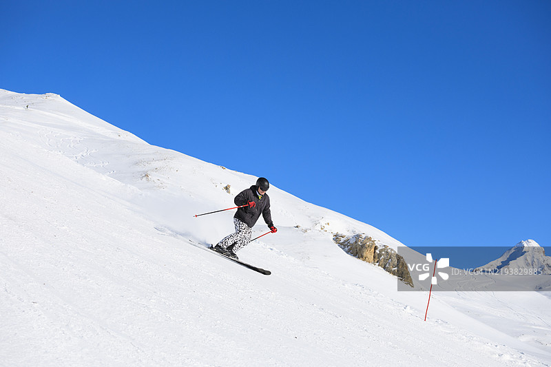 滑雪冬季运动。英俊的运动员在阳光明媚的滑雪胜地享受滑雪。欧洲阿尔卑斯山的雪山，滑雪区域瓦尔迪泽尔 - 蒂涅。图片素材