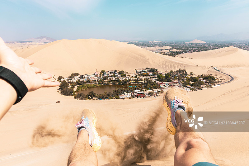 男子从沙丘上以个人视角思考秘鲁的瓦卡奇纳绿洲图片素材