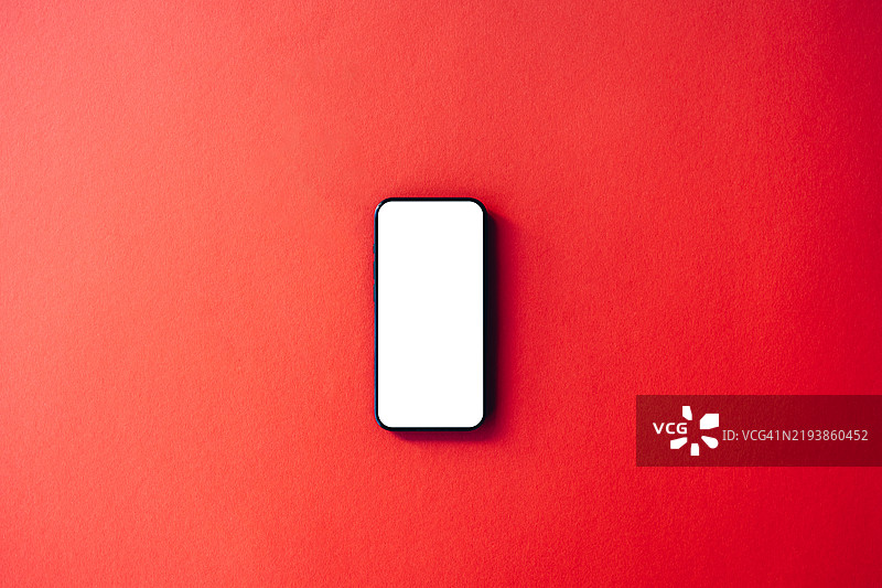 简约的红色智能手机，白色屏幕，背景为鲜艳的红色，完美适用于科技和现代生活方式的概念图片素材