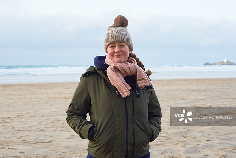 冬季沿海散步时微笑的女性肖像图片素材