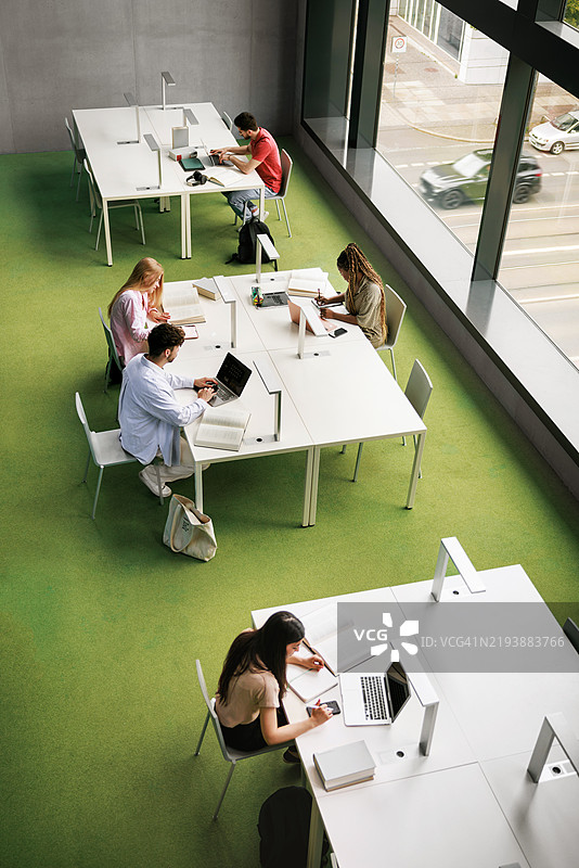 图书馆学习区的鸟瞰图显示了一个多元化的学生群体图片素材