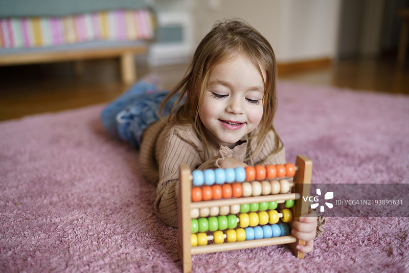 可爱的小女孩在玩算盘图片素材