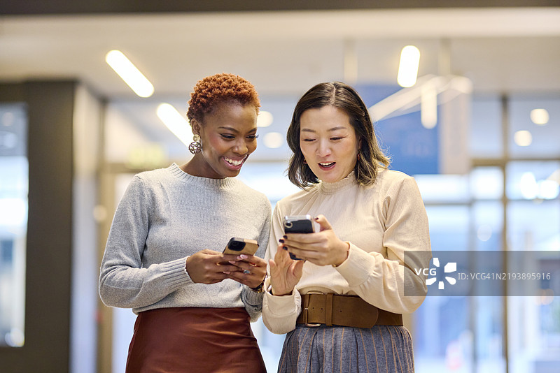 两位女性在手机上分享内容图片素材