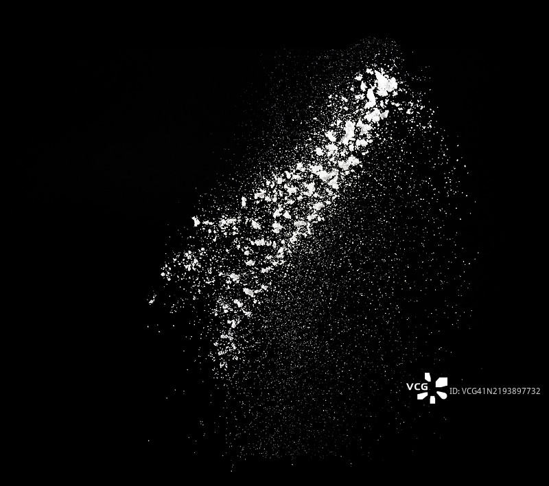 黑色背景下，厨房里糖粒如云般洒落。图片素材