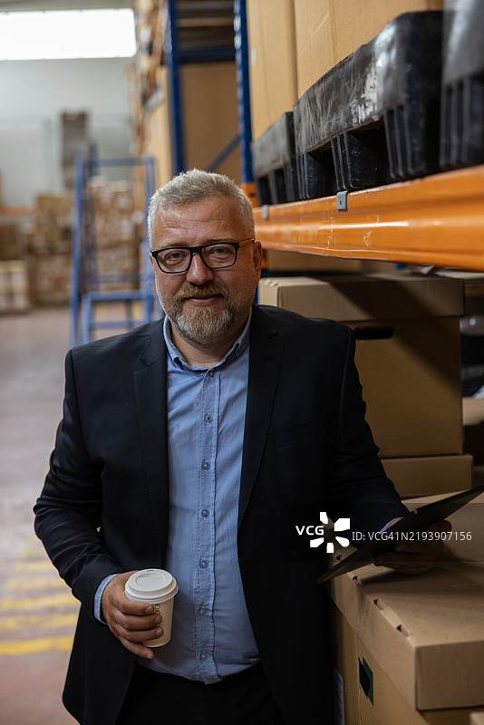 高效的工厂管理：微笑的高级经理、商人或首席执行官使用平板电脑监控工业工厂仓库的生产情况。图片素材