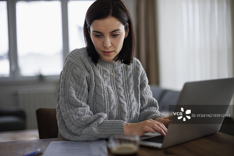 专注的女性正在为求职申请撰写简历图片素材