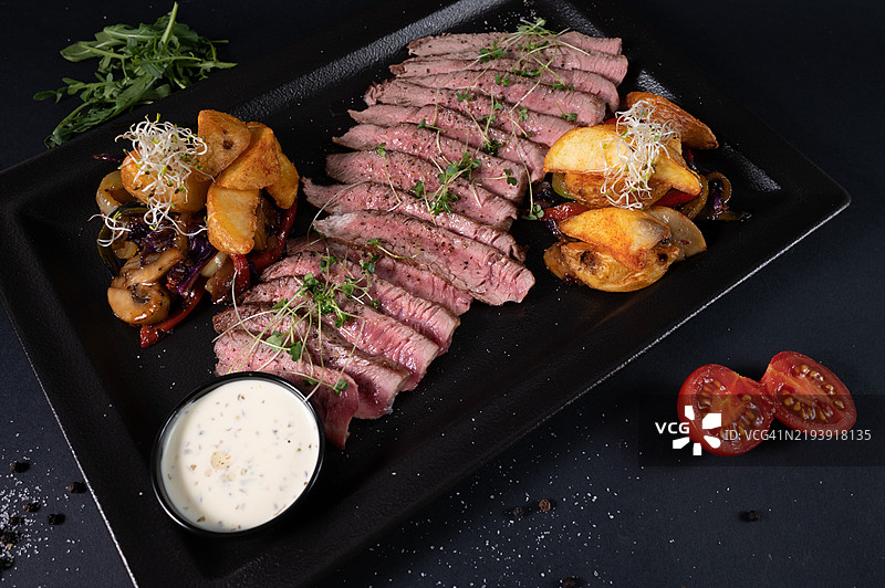 切片肉类、炸土豆、洋葱、西红柿、火箭菜和酱汁的俯视图图片素材