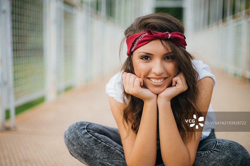 年轻女性在阳光明媚的户外桥上愉快地微笑图片素材