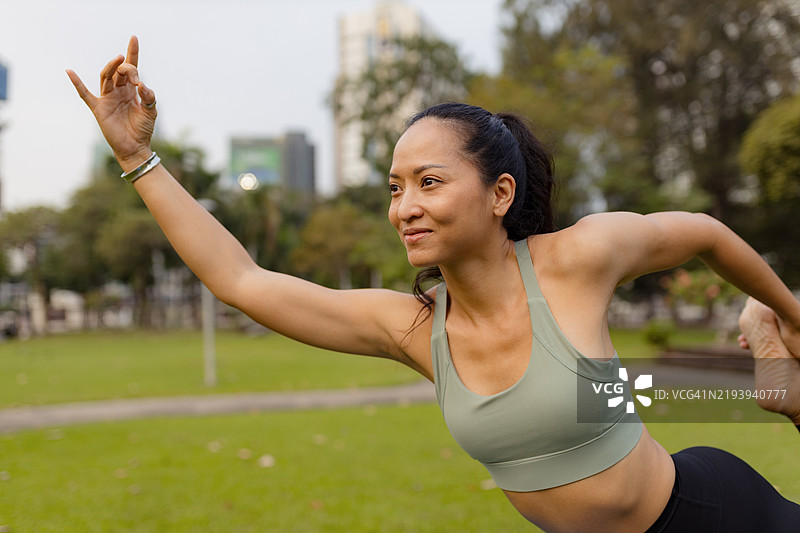 阳光明媚的早晨，女性在公园户外练习瑜伽图片素材