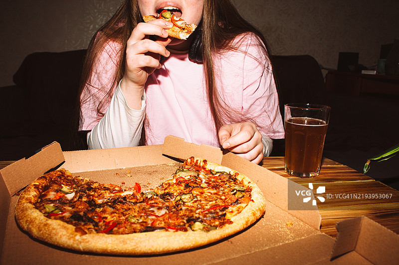 年轻女性在家派对上吃披萨图片素材