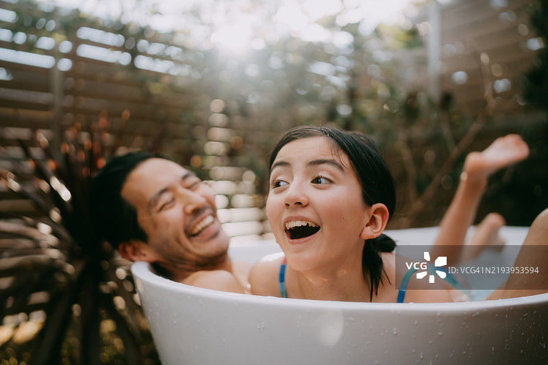 快乐的小女孩和她的父亲在浴缸里图片素材