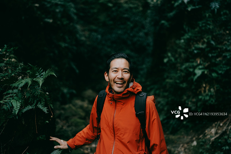 快乐的男人在郁郁葱葱的峡谷中徒步旅行图片素材