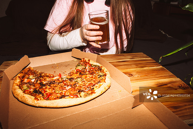 年轻女性在家派对上吃披萨喝手工啤酒图片素材