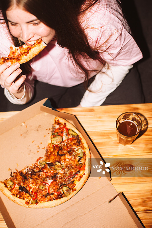 快乐的年轻女性在家派对上吃披萨图片素材