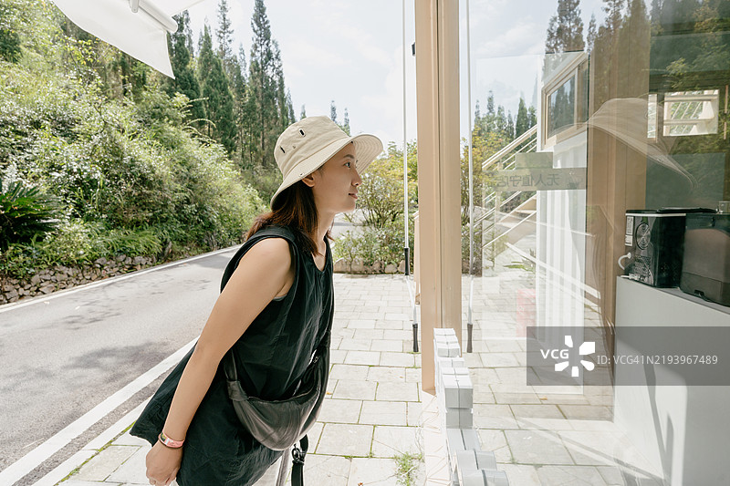 一位年轻的亚洲女性戴着太阳帽在旅途中图片素材