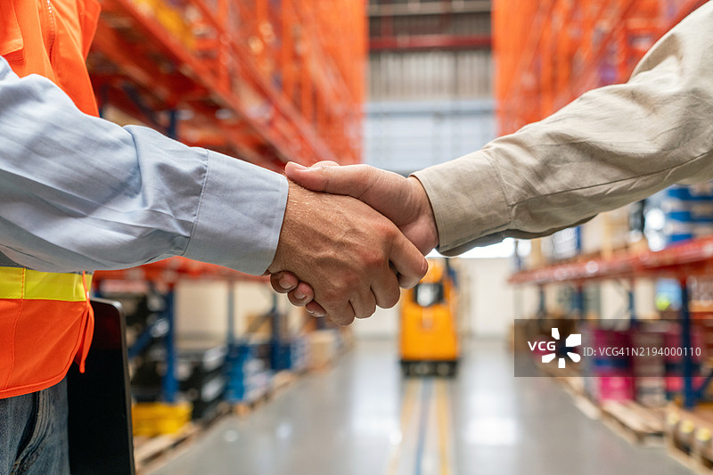 仓库人员的握手、协议和团队合作，供应链的会议和交易。合作伙伴关系、物流和管理的握手，分销协作和快递公司。图片素材