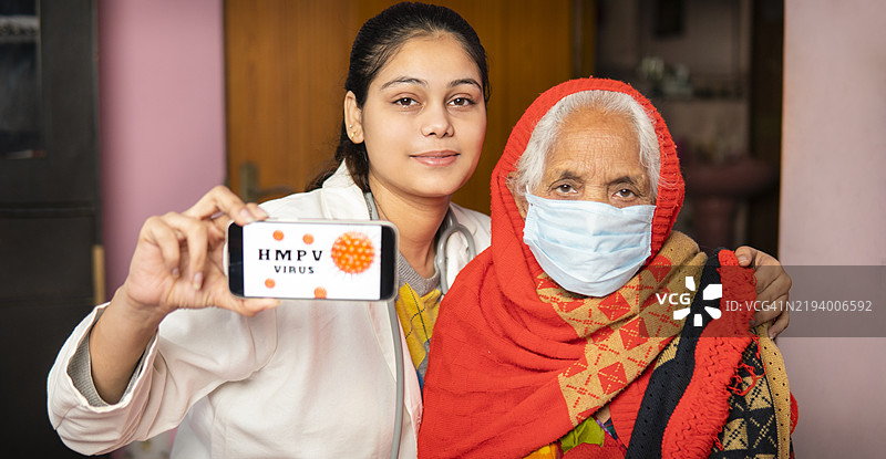年轻女医生与老年女性患者展示含有呼吸道合胞病毒（HMPV）警告的智能手机。图片素材