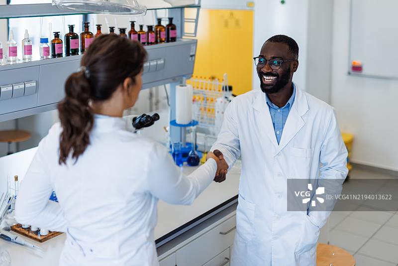 两位科学家在实验室握手图片素材