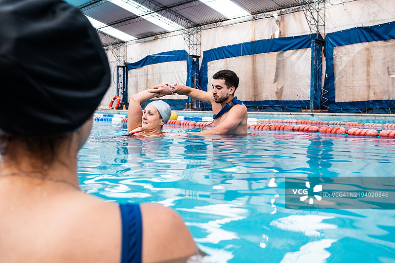 救生员在游泳池教授游泳者救援训练图片素材