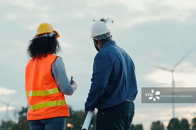 工程师在风力发电场进行无人机辅助检查图片素材