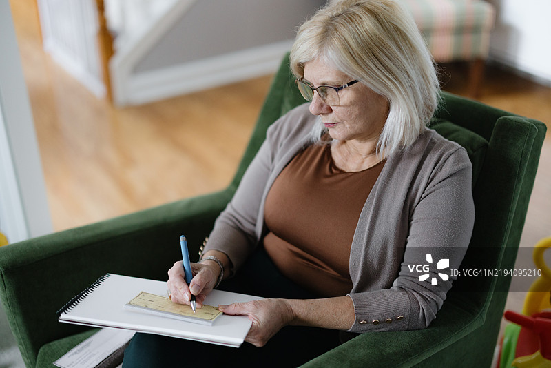 专注的女性在家里的厨房环境中处理文件图片素材