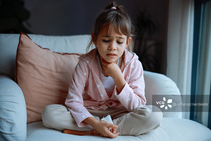 生病的小女孩在客厅里咳嗽图片素材