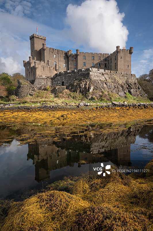 邓维根城堡倒映在低潮时满是海藻的宁静海湾中。邓维根，斯凯岛，苏格兰。图片素材