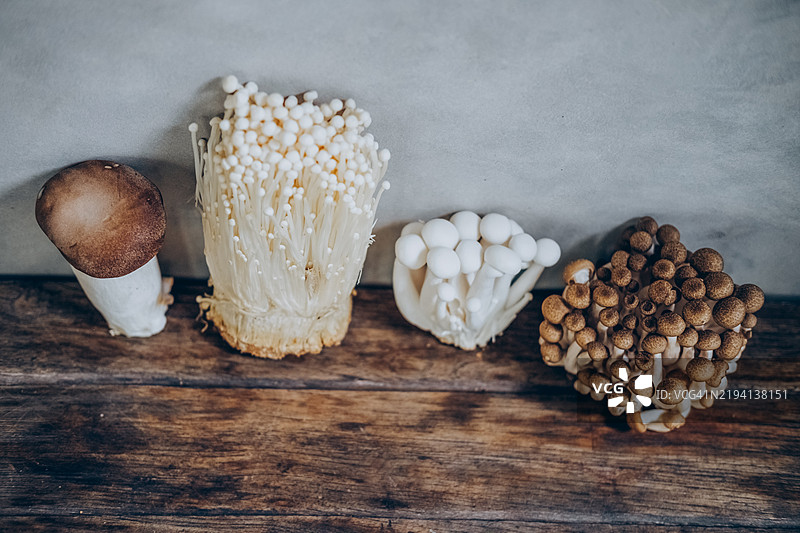 高角度视图展示可食用的亚洲蘑菇放在木桌上。图片素材