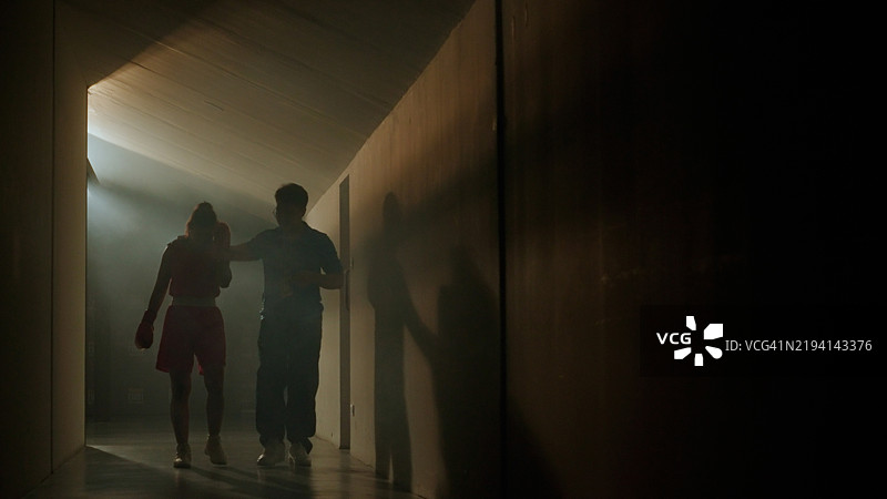 女拳击手与主教练在走道上行走图片素材