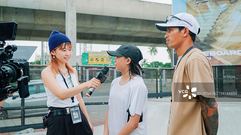 记者在滑板比赛中采访滑手图片素材