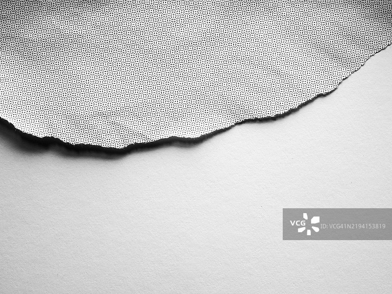 白色撕裂海报，上面有灰色和黑色的点，背景是干净的空白白色。图片素材