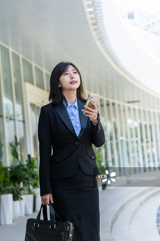 女商人站着使用手机图片素材
